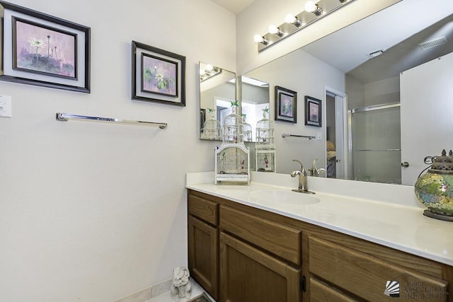 bathroom with vanity and a shower with shower door