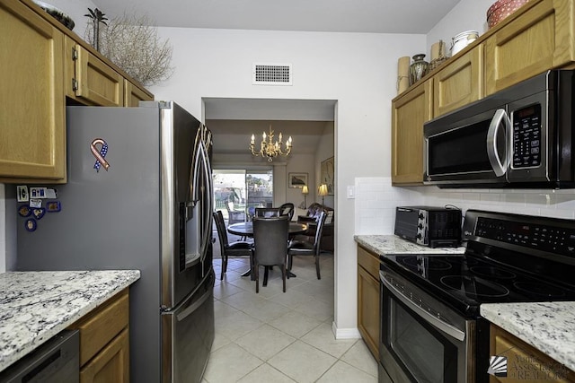 kitchen with pendant lighting, light stone counters, appliances with stainless steel finishes, and a chandelier