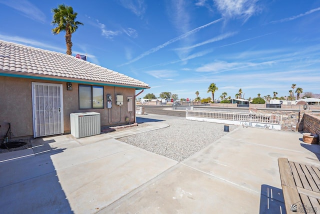 view of patio with cooling unit and fence