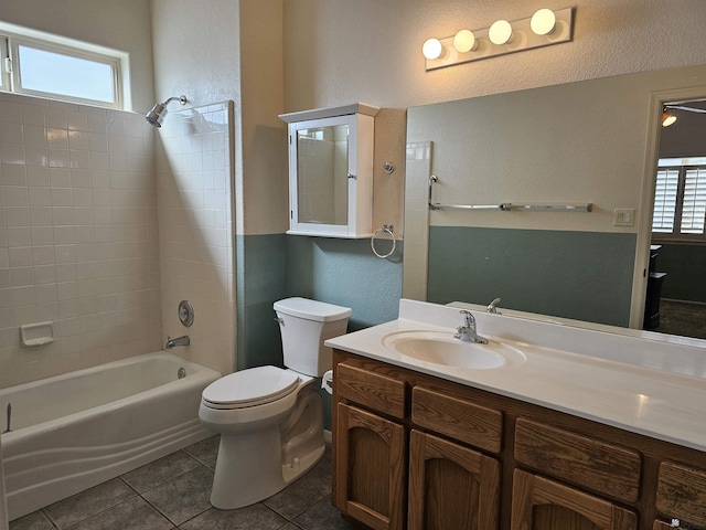 full bathroom featuring tile patterned floors, vanity, tiled shower / bath combo, and toilet