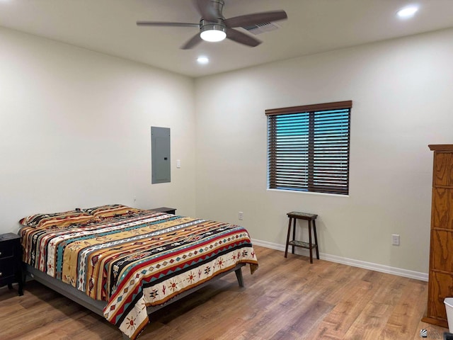 bedroom with wood-type flooring, electric panel, and ceiling fan