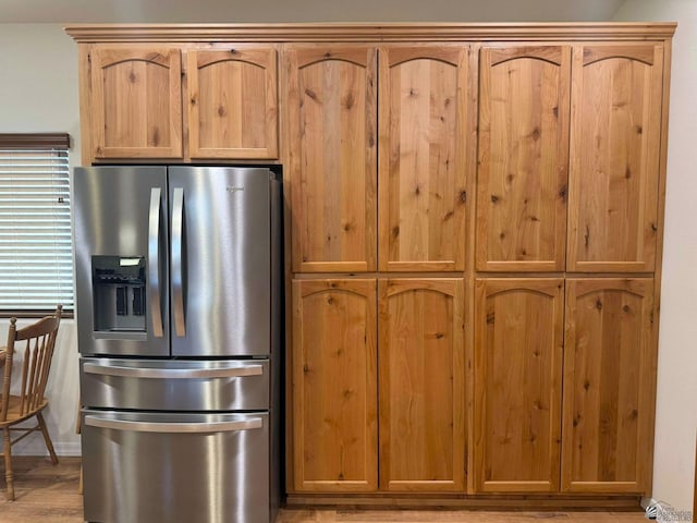 kitchen with stainless steel fridge with ice dispenser and light hardwood / wood-style floors