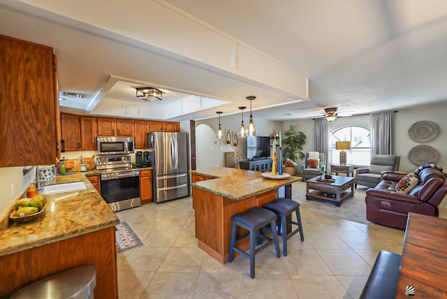 kitchen featuring light stone counters, appliances with stainless steel finishes, sink, and light tile patterned floors