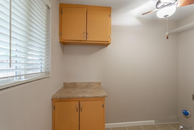 laundry room featuring ceiling fan and light tile patterned floors