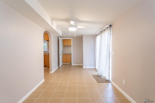 tiled spare room featuring ceiling fan