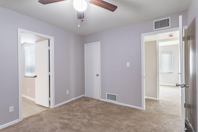 unfurnished bedroom with ceiling fan and light colored carpet