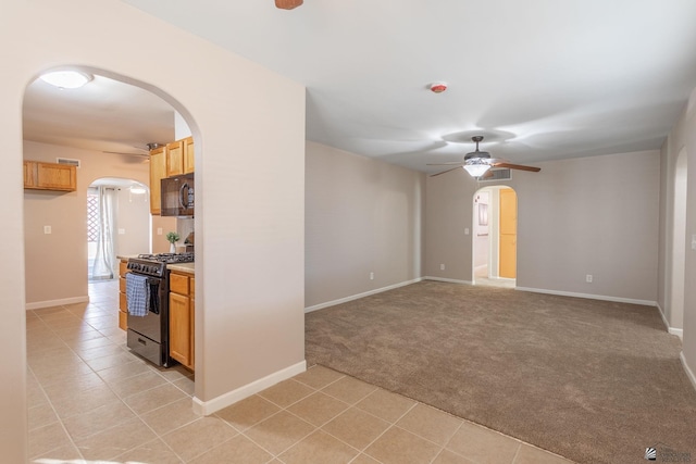 spare room featuring light carpet and ceiling fan