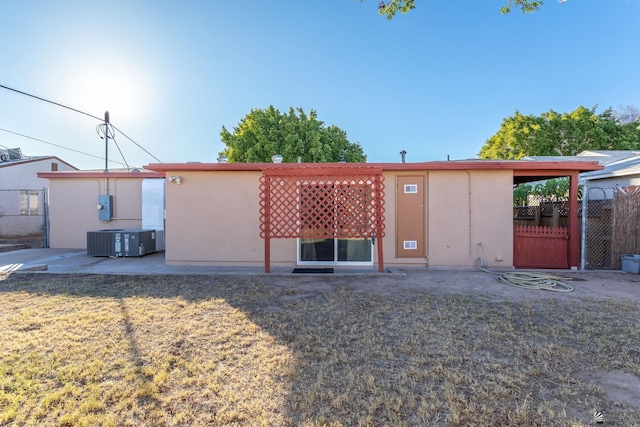 rear view of property with a yard and central air condition unit