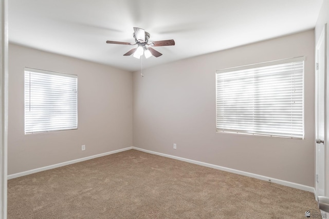 carpeted spare room with ceiling fan