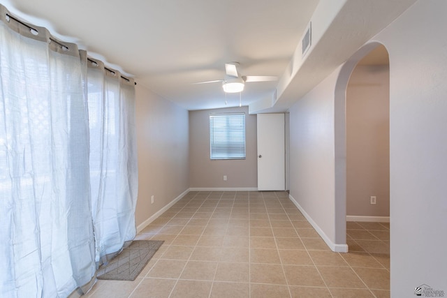 tiled spare room with ceiling fan