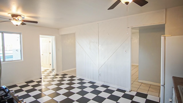 empty room featuring ceiling fan and a barn door