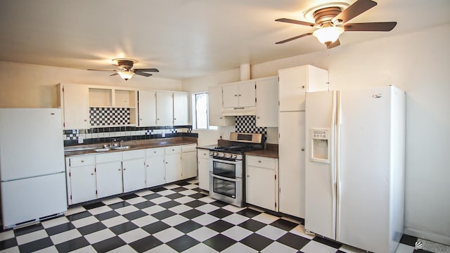 kitchen featuring sink, double oven range, white refrigerator, white fridge with ice dispenser, and white cabinets