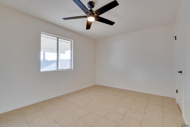 empty room featuring ceiling fan, a textured ceiling, and baseboards