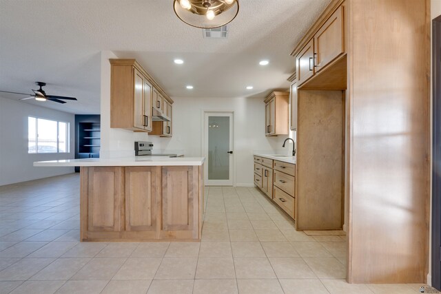 kitchen featuring light countertops, a peninsula, light brown cabinets, and stainless steel electric stove