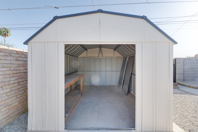 view of shed featuring a garage and fence