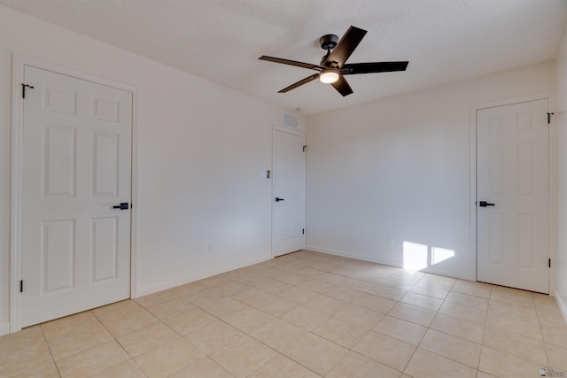 unfurnished room with a ceiling fan, visible vents, a textured ceiling, and light tile patterned floors