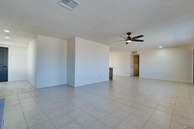 empty room with light tile patterned floors, ceiling fan, and visible vents