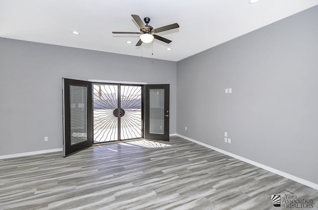 spare room featuring ceiling fan, french doors, and light wood-type flooring