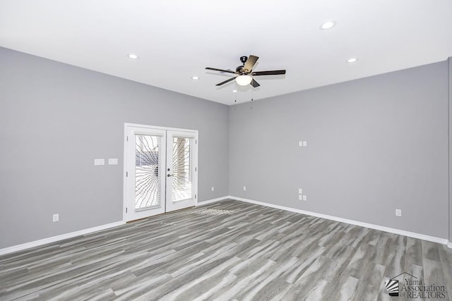 empty room with french doors, light wood-type flooring, and ceiling fan