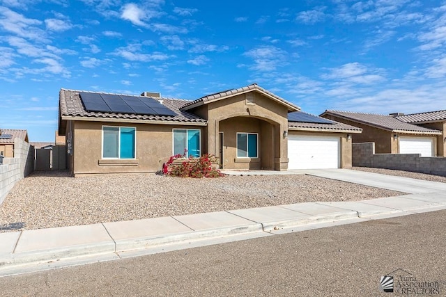 view of front of property with a garage and solar panels