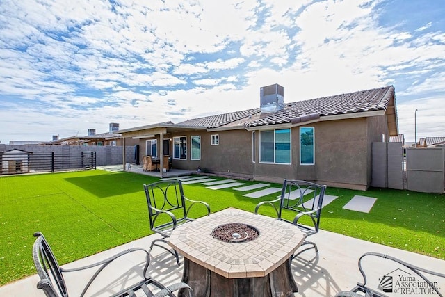 back of house with a yard, central AC, a patio, and an outdoor fire pit