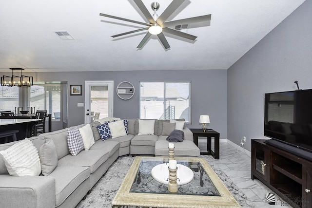 living room featuring ceiling fan with notable chandelier