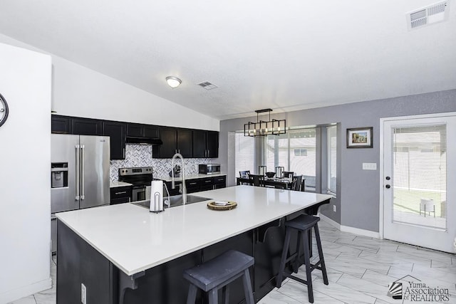 kitchen featuring a kitchen island with sink and a kitchen bar