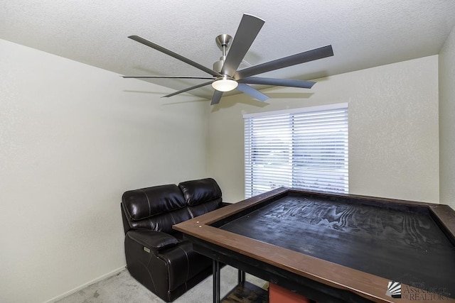 carpeted home office featuring ceiling fan and a textured ceiling