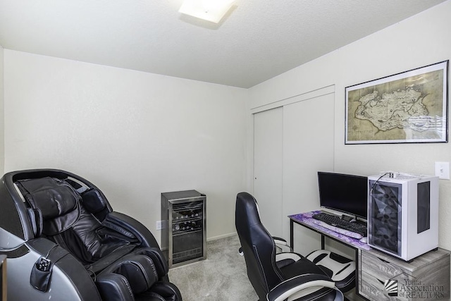 office with wine cooler, light colored carpet, and a textured ceiling