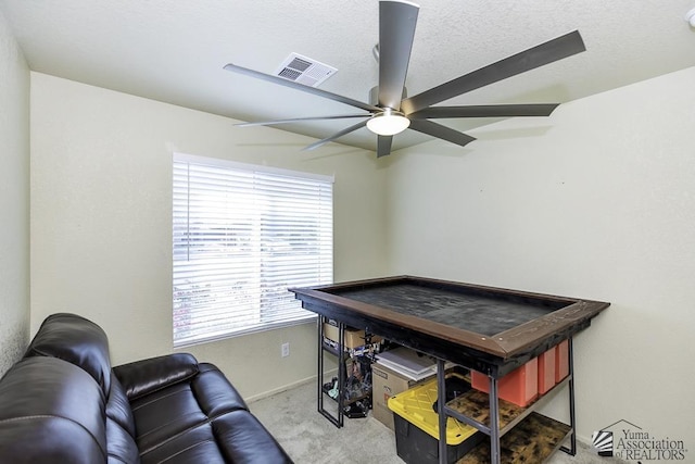 office space featuring light carpet, a textured ceiling, and ceiling fan