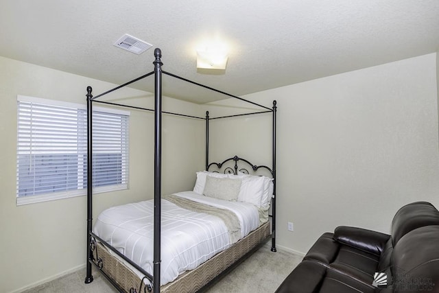 bedroom featuring light colored carpet and a textured ceiling