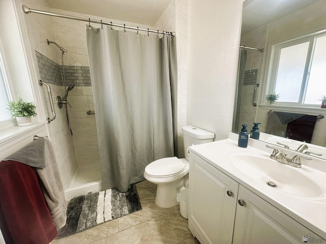 bathroom with toilet, a tile shower, and vanity