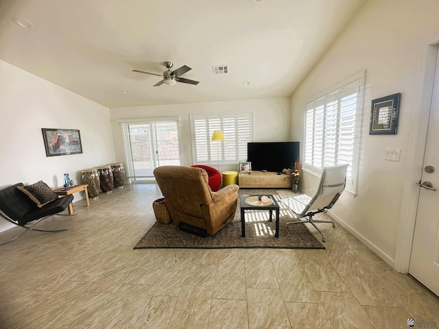 living room with a ceiling fan, visible vents, vaulted ceiling, and baseboards