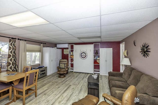 living room featuring light hardwood / wood-style floors and a drop ceiling