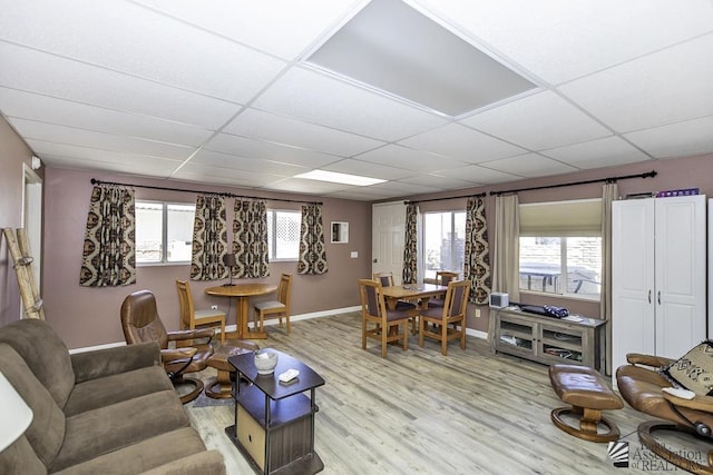 living room featuring light hardwood / wood-style flooring and a paneled ceiling