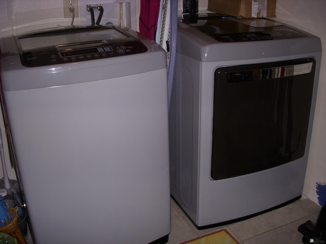 washroom with separate washer and dryer and light tile patterned floors