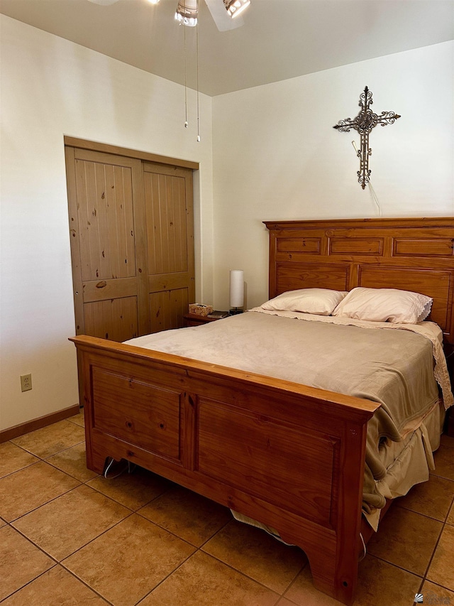 tiled bedroom with ceiling fan and a closet