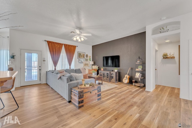 living room featuring ceiling fan and light wood-type flooring