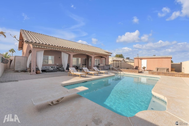 view of swimming pool with a diving board and a patio