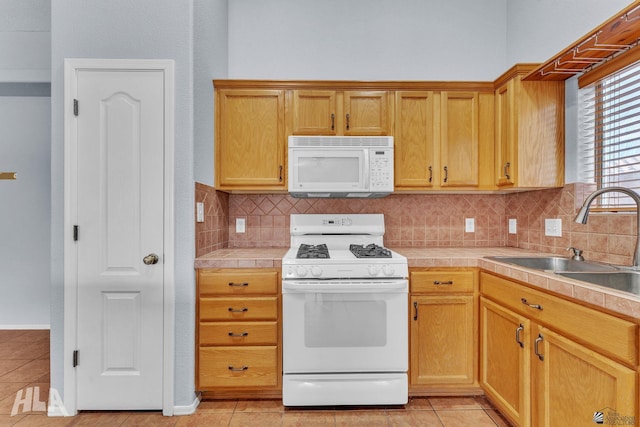 kitchen with tasteful backsplash, white appliances, a sink, and light tile patterned floors