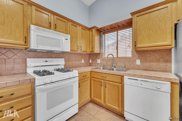 kitchen featuring tile countertops, light tile patterned floors, white appliances, a sink, and tasteful backsplash