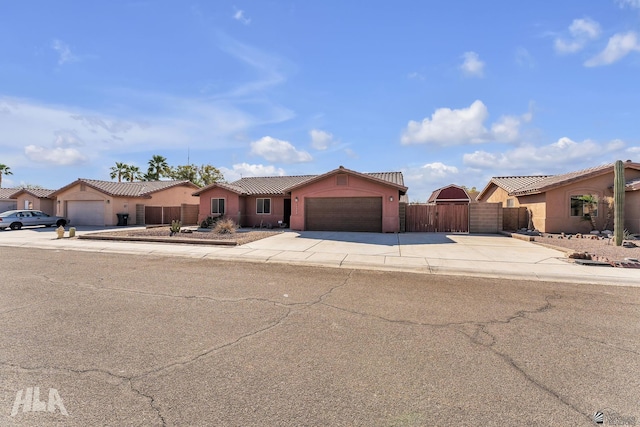 ranch-style house with concrete driveway, a residential view, an attached garage, fence, and stucco siding