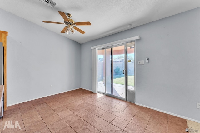 empty room with light tile patterned floors, a textured ceiling, visible vents, baseboards, and a ceiling fan