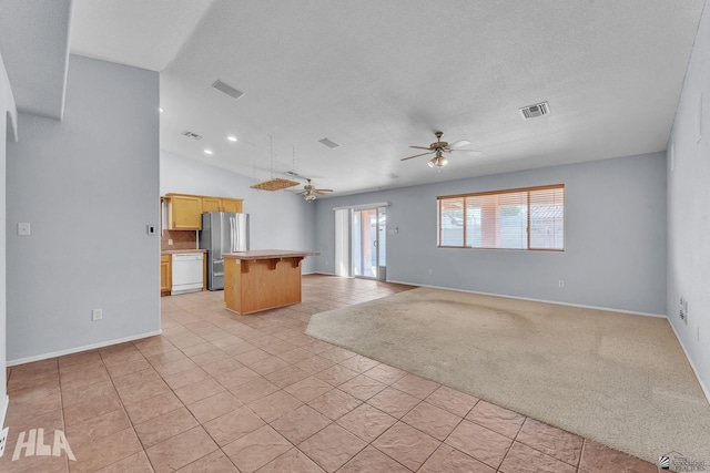 unfurnished living room featuring a ceiling fan, lofted ceiling, visible vents, and light carpet