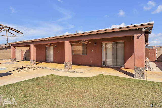 back of property featuring ceiling fan, a lawn, a patio area, and stucco siding