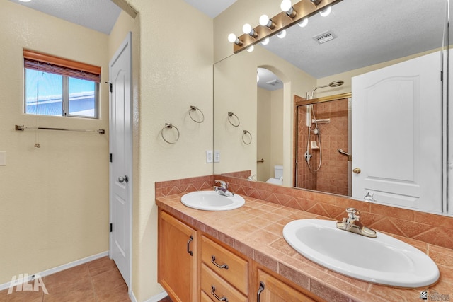 bathroom featuring visible vents, a sink, toilet, and double vanity