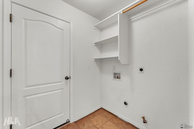 clothes washing area with laundry area, light tile patterned floors, baseboards, hookup for a gas dryer, and hookup for a washing machine