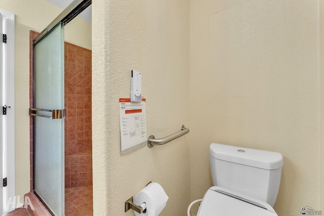 full bathroom featuring toilet and a shower stall