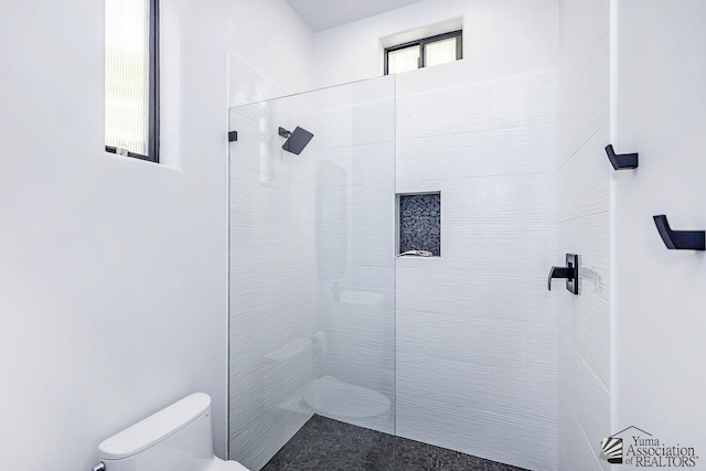 bathroom featuring toilet and tiled shower