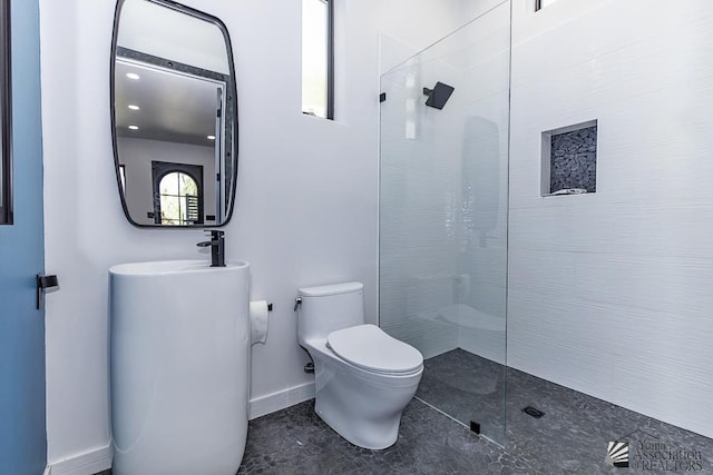 bathroom featuring toilet and a tile shower